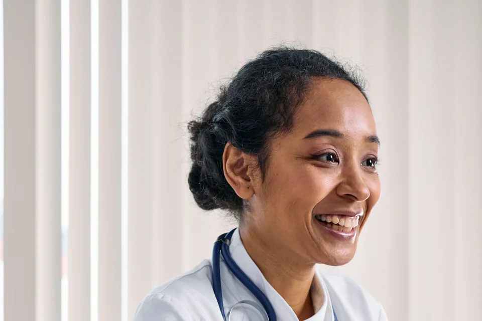 Black woman doctor smiling during a consultation.